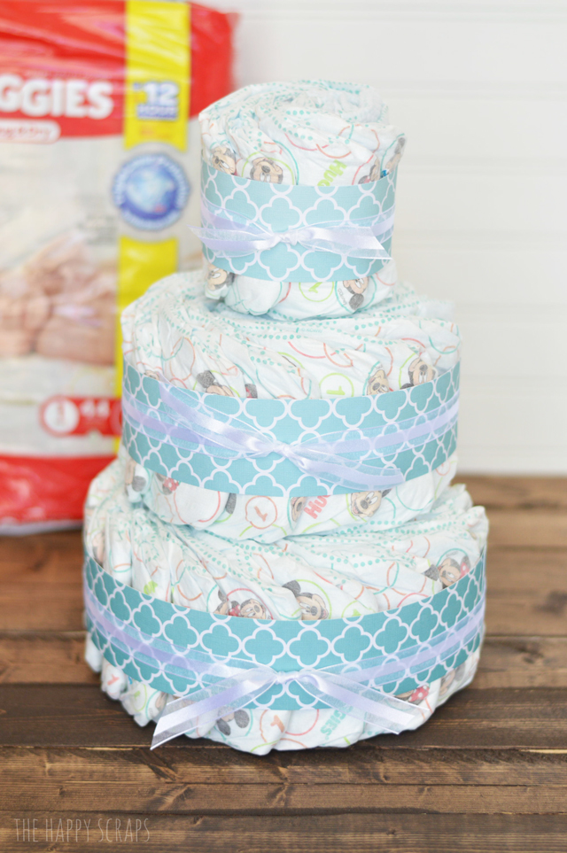 Need a baby gift? This Huggies diaper cake takes less than an hour to make and is the perfect First Time Mom Gift. Make one for a give today!