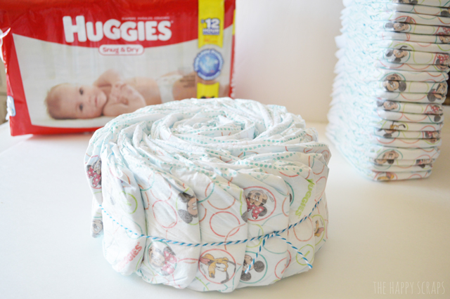 Need a baby gift? This Huggies diaper cake takes less than an hour to make and is the perfect First Time Mom Gift. Make one for a give today!
